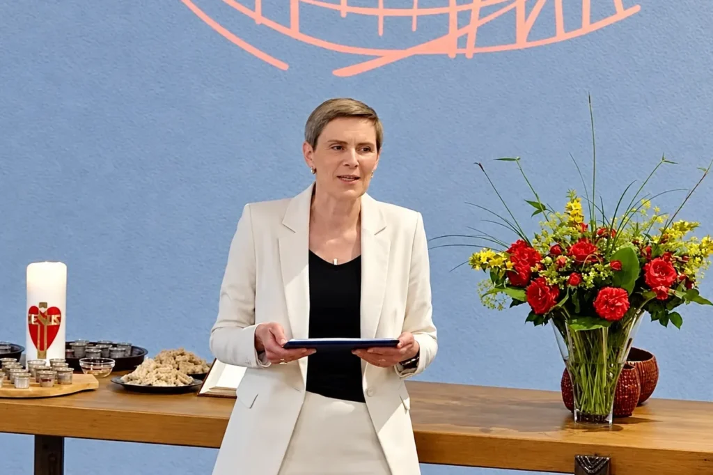 Pastorin Ruth - Andrea Möller steht vor einem Tisch mit Brot und Wein für das Abendmahl.